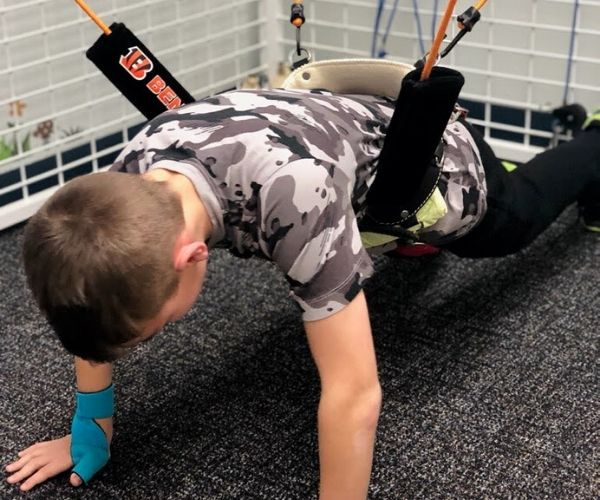 An 8 year old boy using the Universal Exercise Unit under the supervision of physical therapist Lisa Davison.