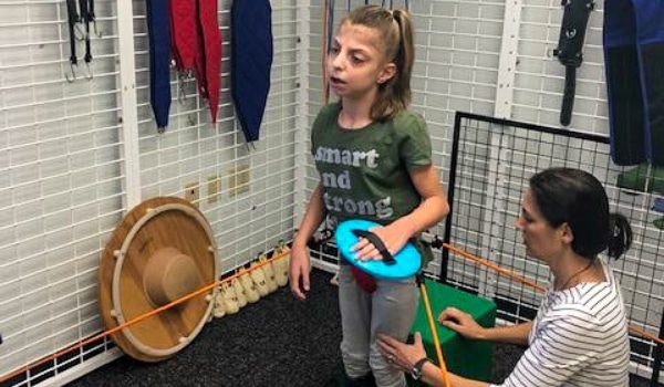 Girl receiving therapy in a spider cage or UEU.